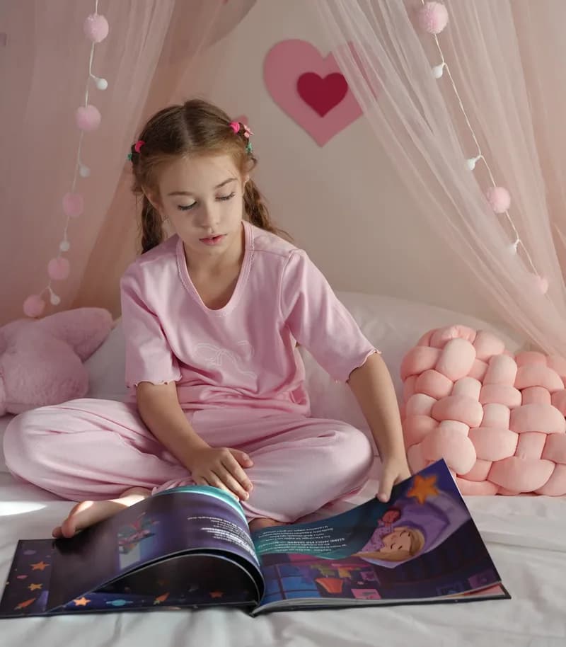 Una bambina sfoglia la Notte Magica sul letto